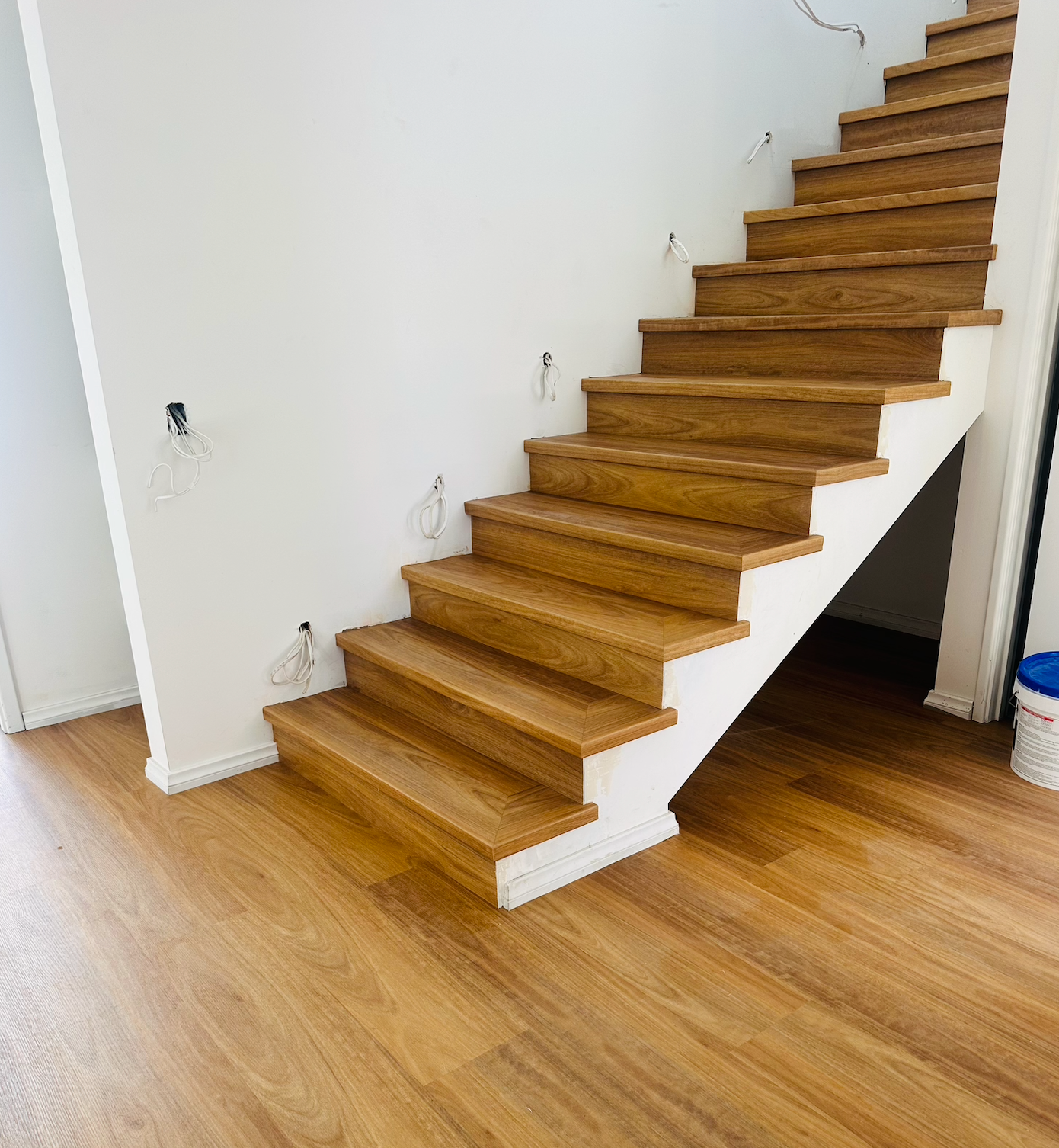 Wooden staircase with white walls