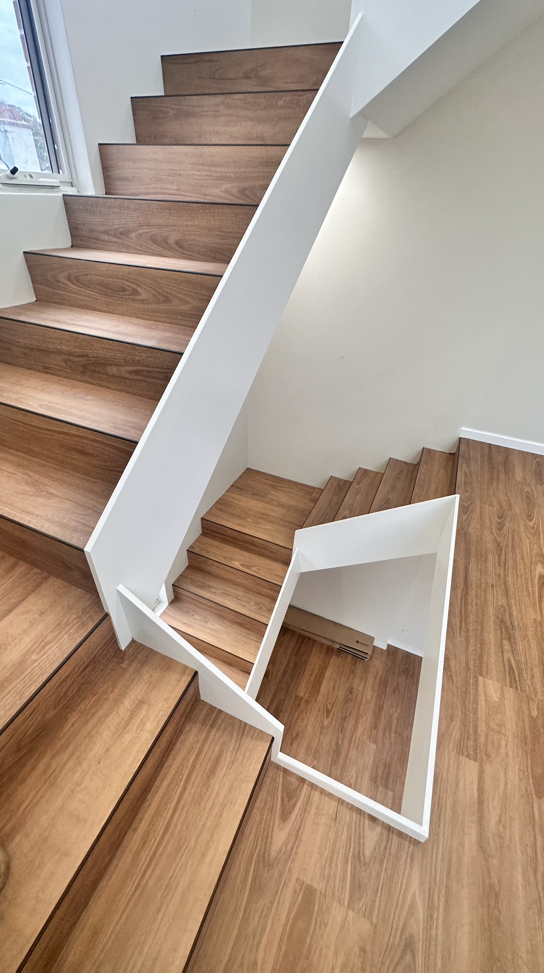 Modern wooden staircase with white railings