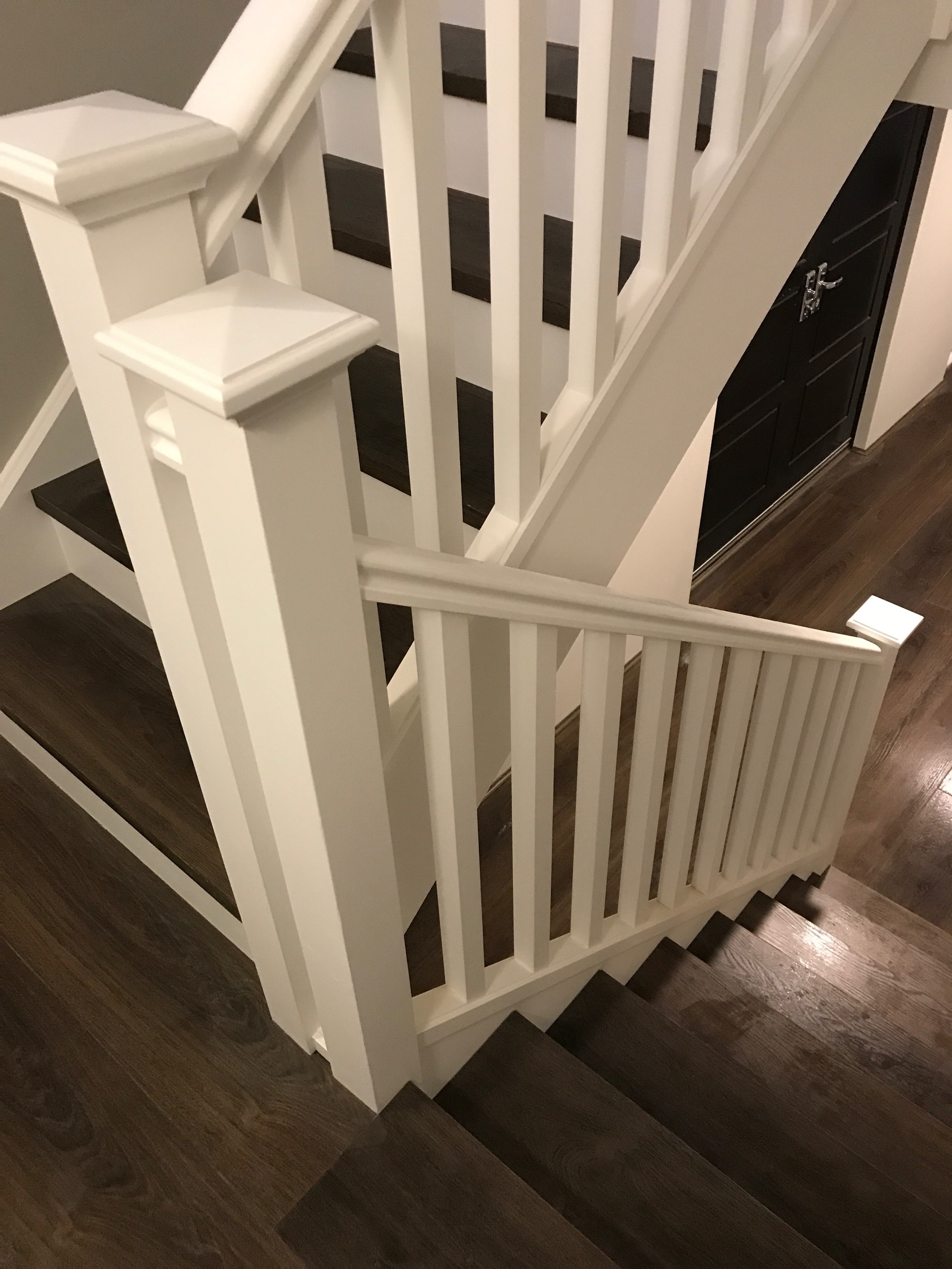White staircase with wooden handrail
